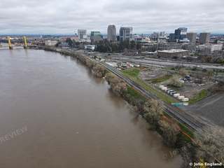 River and Yellow Lift Bridge – Aerial over a high river with yellow lift bridge and downtown beyond.