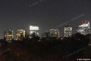 Downtown Towers Glowing at Night – Downtown skyline at night across the trees, Aug 11, 2021.