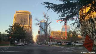 Downtown Towers at Golden Hour – Downtown towers catching golden-hour light along a tree-lined street. Feb 23, 2021. John England.