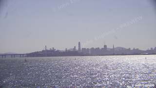 San Francisco Skyline Across Sparkling Water – The San Francisco skyline and Bay Bridge across sunlit bay water. Jan 2, 2019. John England.